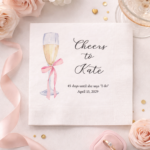 pink bow on champagne glass with names on personalized cocktail napkin for bridal shower