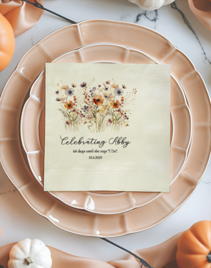 Close-up of personalized floral bridal shower cocktail napkin on an elegant place setting