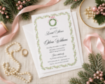 Flat lay of Christmas bridal shower invitation with pink ribbon and evergreen accents