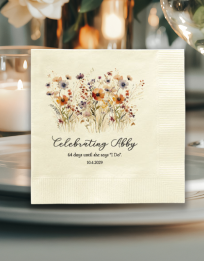 Personalized cocktail napkin with wildflower design displayed at a bridal shower place setting